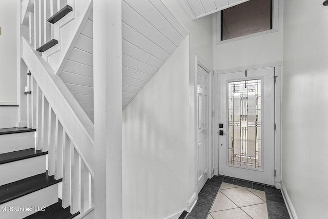 entrance foyer featuring stairway, tile patterned flooring, and baseboards