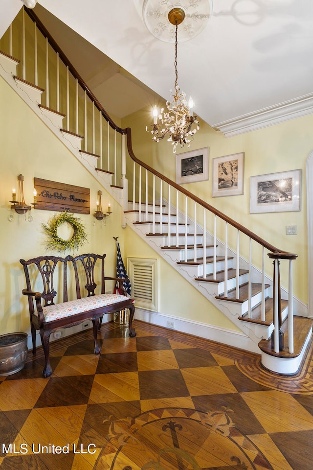 stairway featuring a notable chandelier