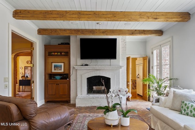 living room featuring beam ceiling, a brick fireplace, hardwood / wood-style flooring, and wood ceiling