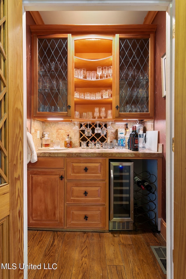 bar with wine cooler, decorative backsplash, and hardwood / wood-style floors