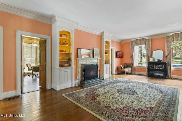 living room with crown molding, hardwood / wood-style flooring, and built in features