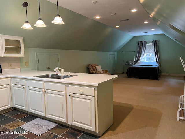 kitchen featuring kitchen peninsula, white cabinetry, decorative light fixtures, and sink