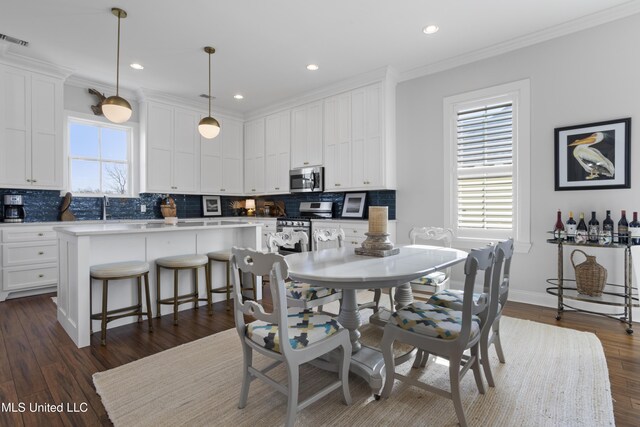 122 Aiken Rd, Waveland, MS 39576 - dining room featuring crown molding, a healthy amount of sunlight, and dark wood-type flooring