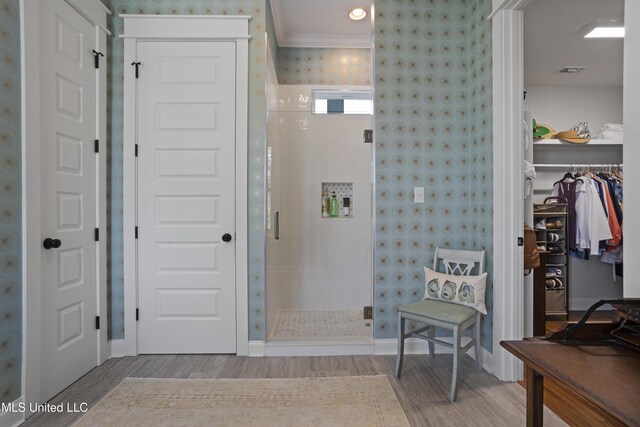 122 Aiken Rd, Waveland, MS 39576 - bathroom featuring wood finished floors, wallpapered walls, a stall shower, a spacious closet, and crown molding