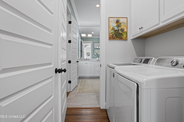 122 Aiken Rd, Waveland, MS 39576 - washroom with washer and dryer, cabinet space, dark wood-style flooring, and a sink