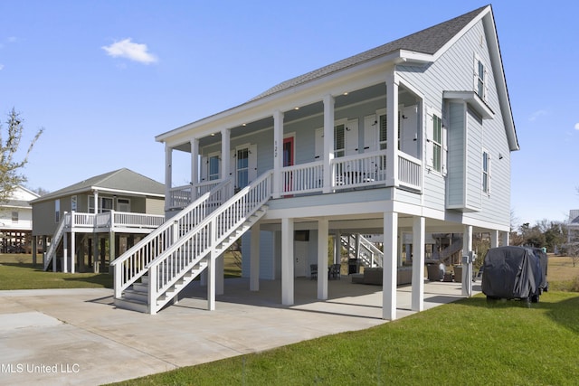 122 Aiken Rd, Waveland, MS 39576 - view of front facade with driveway, a carport, a porch, and a front lawn