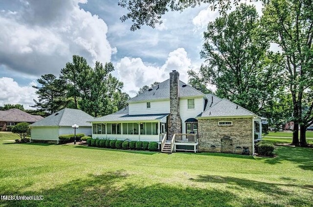 back of property with a chimney, a wooden deck, and a yard