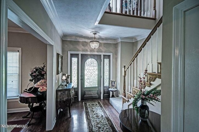 foyer entrance with stairway, a notable chandelier, crown molding, baseboards, and wood finished floors