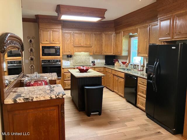 kitchen featuring light hardwood / wood-style floors, black appliances, and a center island