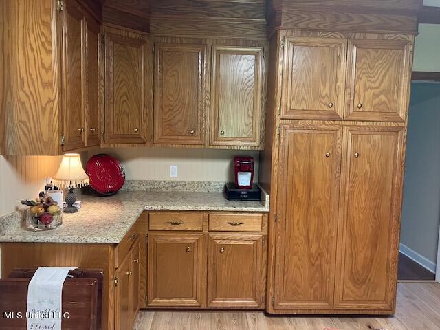 kitchen featuring light stone counters and light hardwood / wood-style floors