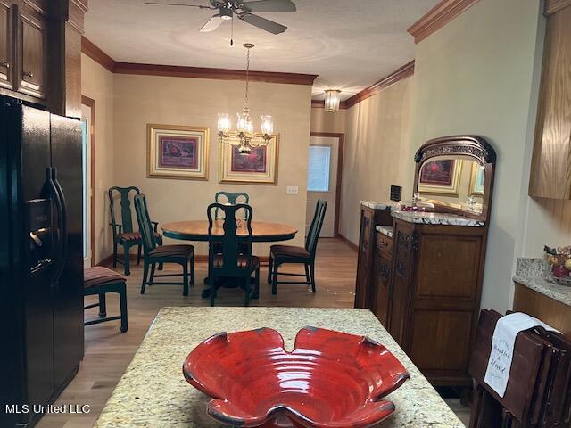 dining area with crown molding, ceiling fan with notable chandelier, and light wood-type flooring