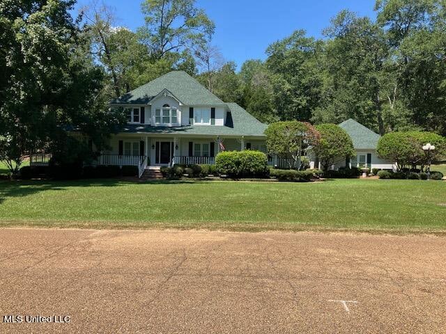 view of front of house featuring covered porch and a front lawn