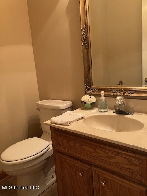 half bathroom featuring vanity and toilet