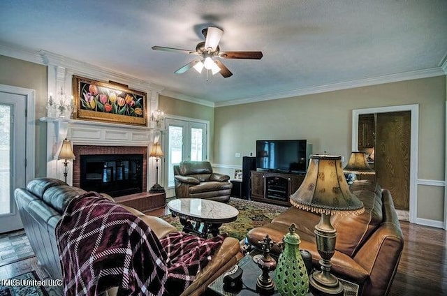 living room featuring crown molding, a brick fireplace, wood-type flooring, and ceiling fan