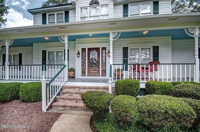 view of exterior entry with covered porch