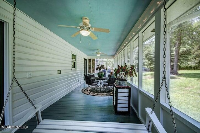 unfurnished sunroom featuring ceiling fan