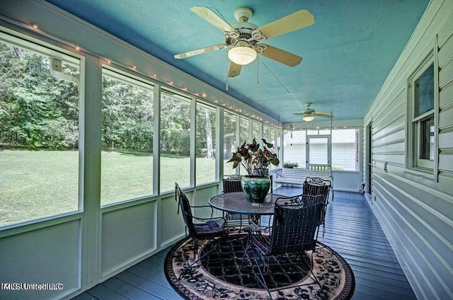 sunroom / solarium with a healthy amount of sunlight, outdoor dining space, and ceiling fan