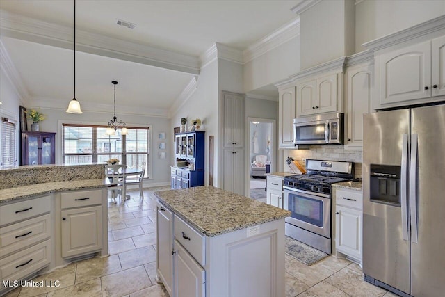 kitchen with light stone counters, decorative light fixtures, stainless steel appliances, backsplash, and ornamental molding