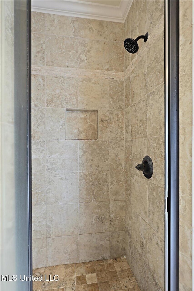 full bath with ornamental molding and a tile shower