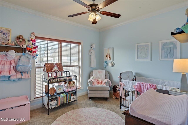 carpeted bedroom with ornamental molding, baseboards, and a ceiling fan