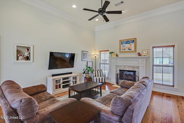 living room with plenty of natural light, crown molding, visible vents, and hardwood / wood-style floors