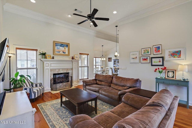 living area featuring visible vents, crown molding, and wood finished floors