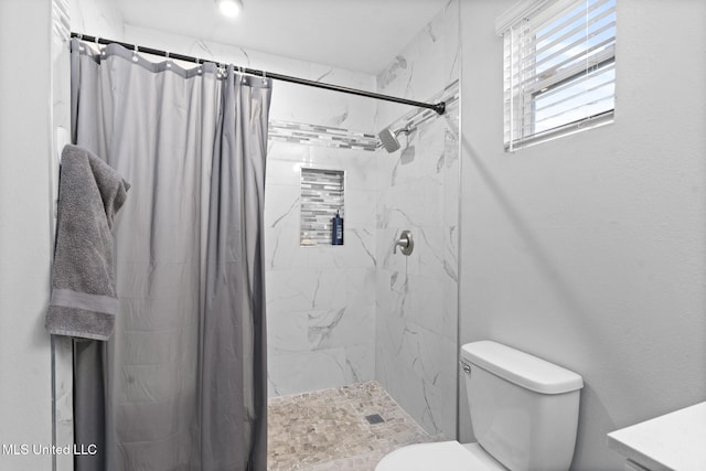 bathroom featuring curtained shower and toilet