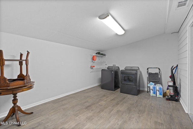 washroom with washing machine and clothes dryer and wood-type flooring