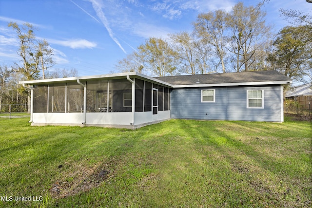 back of property featuring a sunroom and a lawn