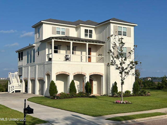 view of front of property with a front lawn, a garage, and a balcony