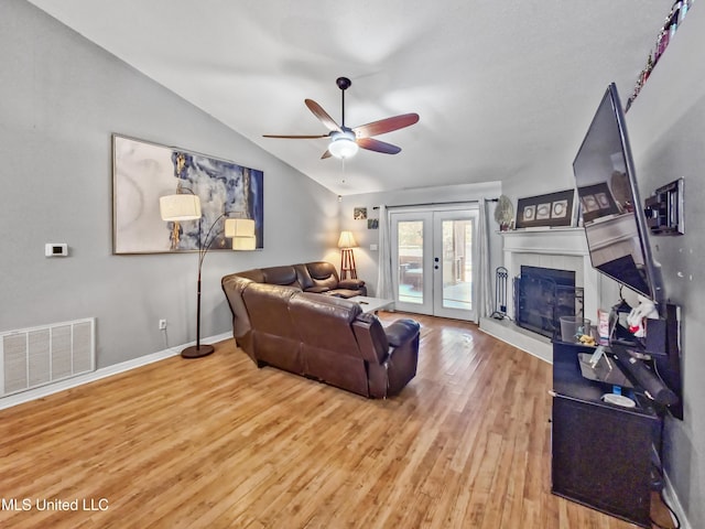11295 Peyton Dr, Gulfport, MS 39503 - living area with lofted ceiling, wood finished floors, ceiling fan, french doors, and a fireplace