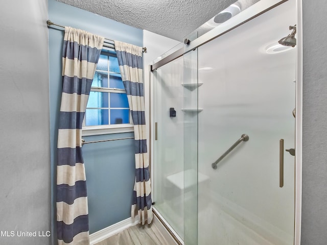 11295 Peyton Dr, Gulfport, MS 39503 - full bath with a stall shower, a textured ceiling, and wood finished floors