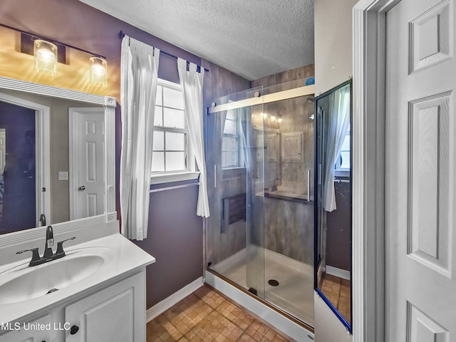 11295 Peyton Dr, Gulfport, MS 39503 - full bath featuring healthy amount of natural light, baseboards, a shower stall, vanity, and a textured ceiling