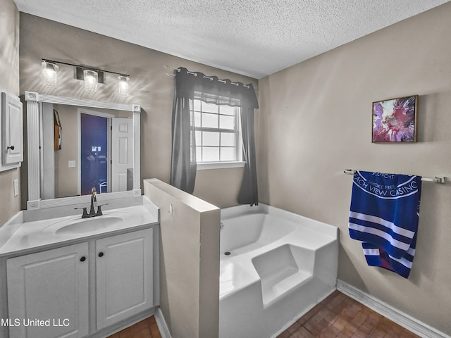 11295 Peyton Dr, Gulfport, MS 39503 - full bath with a textured ceiling, a bath, vanity, and baseboards