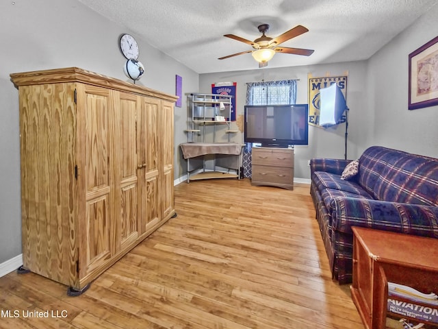 11295 Peyton Dr, Gulfport, MS 39503 - bedroom with light wood finished floors, a textured ceiling, baseboards, and a ceiling fan