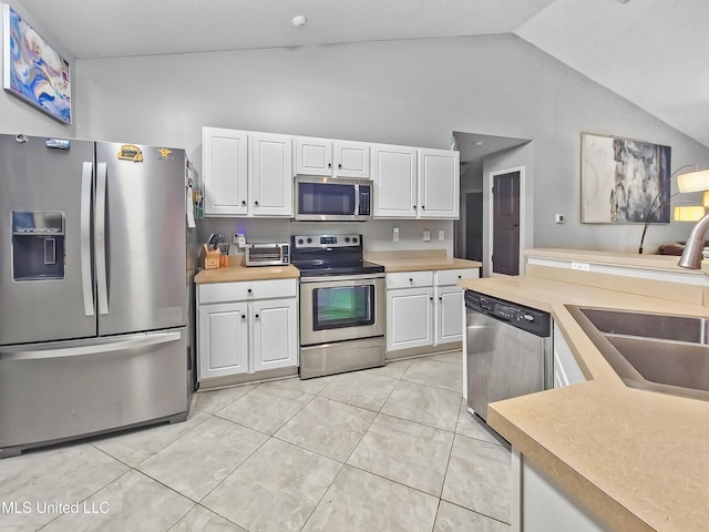 11295 Peyton Dr, Gulfport, MS 39503 - kitchen with stainless steel appliances, light countertops, white cabinets, and high vaulted ceiling