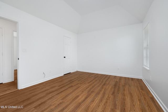unfurnished room with lofted ceiling, baseboards, and wood finished floors