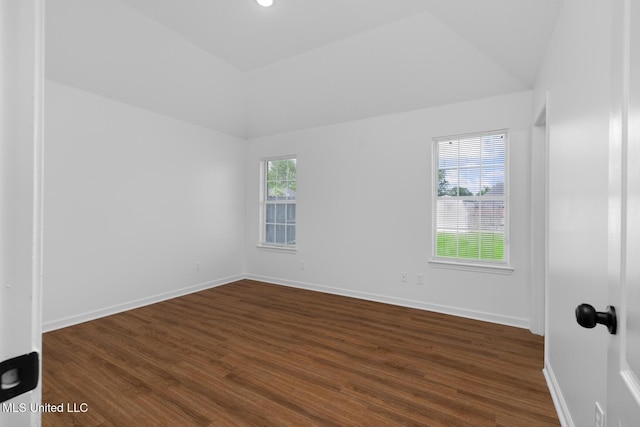 spare room featuring baseboards, dark wood-style flooring, and lofted ceiling