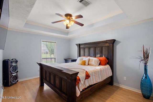 900 Redwood Cv, Byram, MS 39272 - bedroom with a tray ceiling, light wood-style flooring, ornamental molding, and a ceiling fan