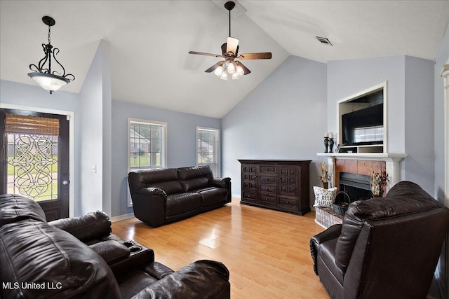 900 Redwood Cv, Byram, MS 39272 - living room featuring a tiled fireplace, vaulted ceiling, a ceiling fan, and light wood-type flooring