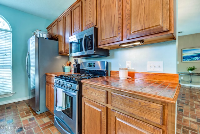 kitchen featuring tile countertops, plenty of natural light, and appliances with stainless steel finishes