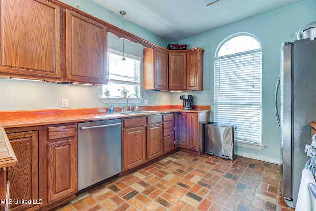 kitchen featuring pendant lighting, stainless steel appliances, a wealth of natural light, and sink