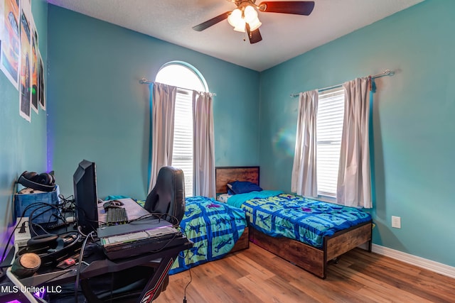 bedroom featuring hardwood / wood-style floors, a textured ceiling, and ceiling fan