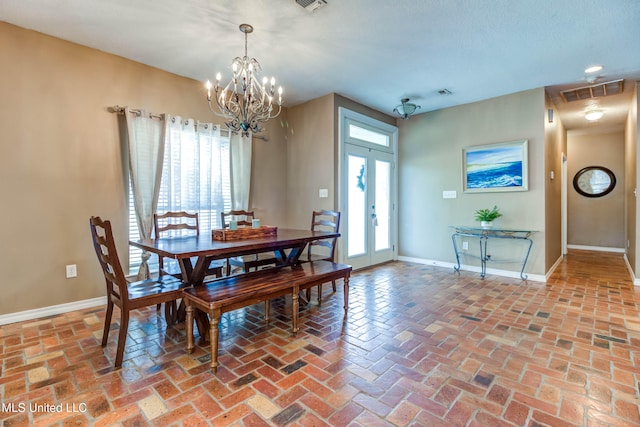 dining room featuring an inviting chandelier and french doors