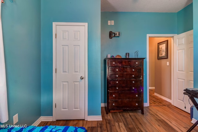 bedroom with hardwood / wood-style floors and a textured ceiling