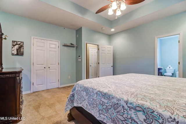 bedroom with ceiling fan, light colored carpet, and connected bathroom