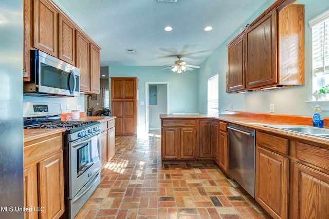 kitchen with kitchen peninsula, stainless steel appliances, and ceiling fan