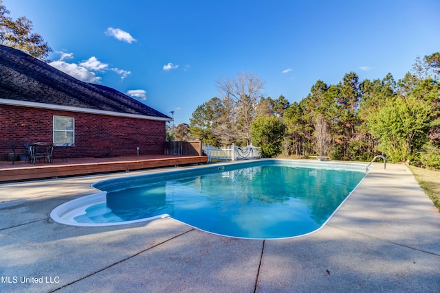 view of swimming pool featuring a patio area and a wooden deck