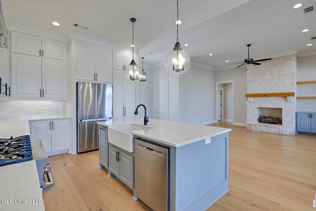 kitchen featuring appliances with stainless steel finishes, light countertops, visible vents, and a sink