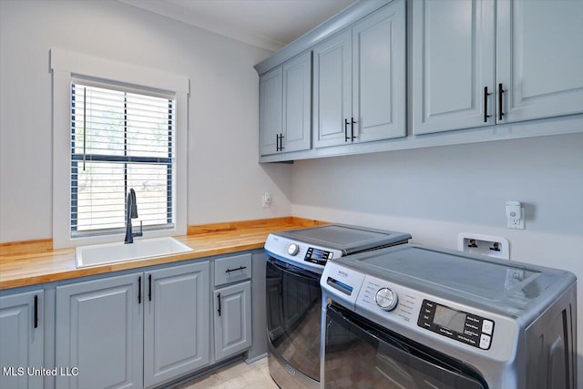 washroom with cabinet space, a sink, and washer and clothes dryer